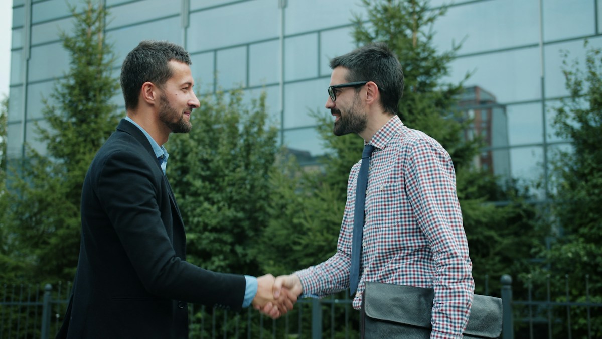Two people discussing a partnership and shaking hands