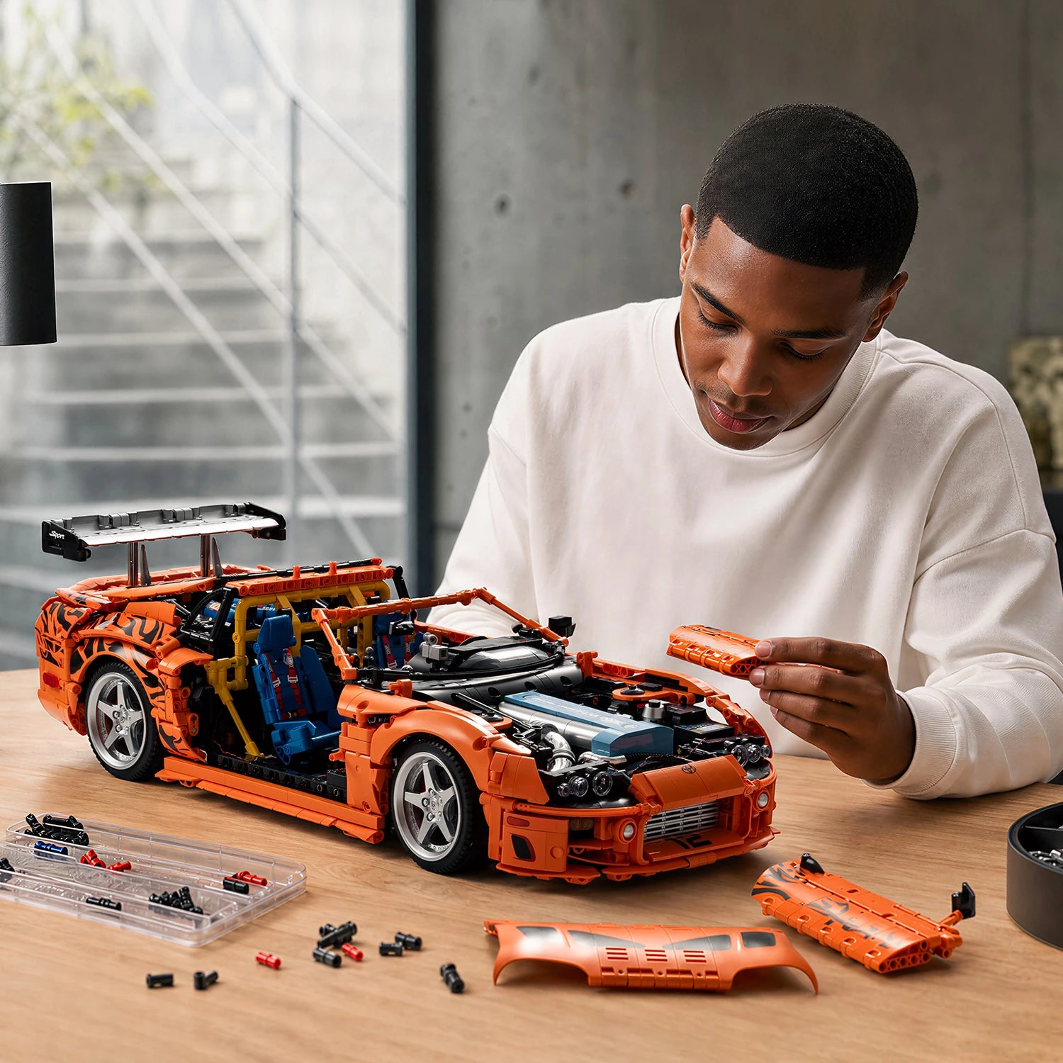 Builder tuning the modular systems of an orange brick-built race car