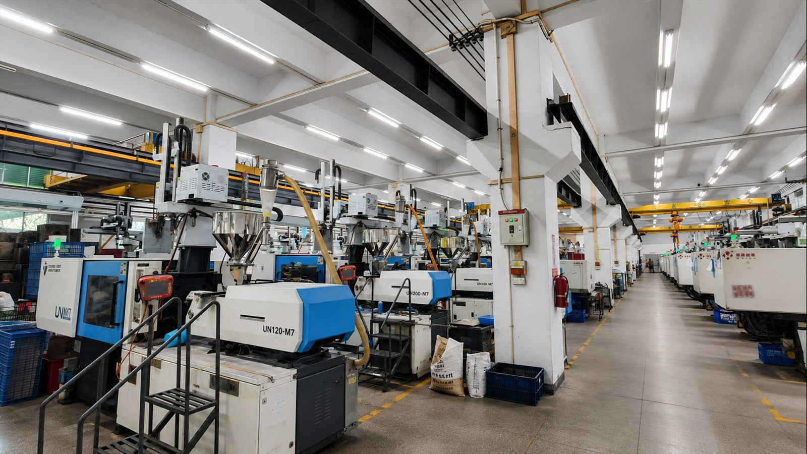 Rows of injection molding machines connected to a central material-feeding system