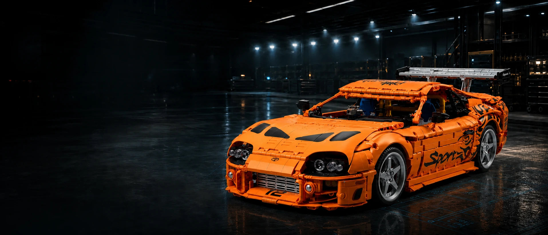 Orange brick-built sports car with a silver-gray rear wing in a black-and-gold motorsport workshop